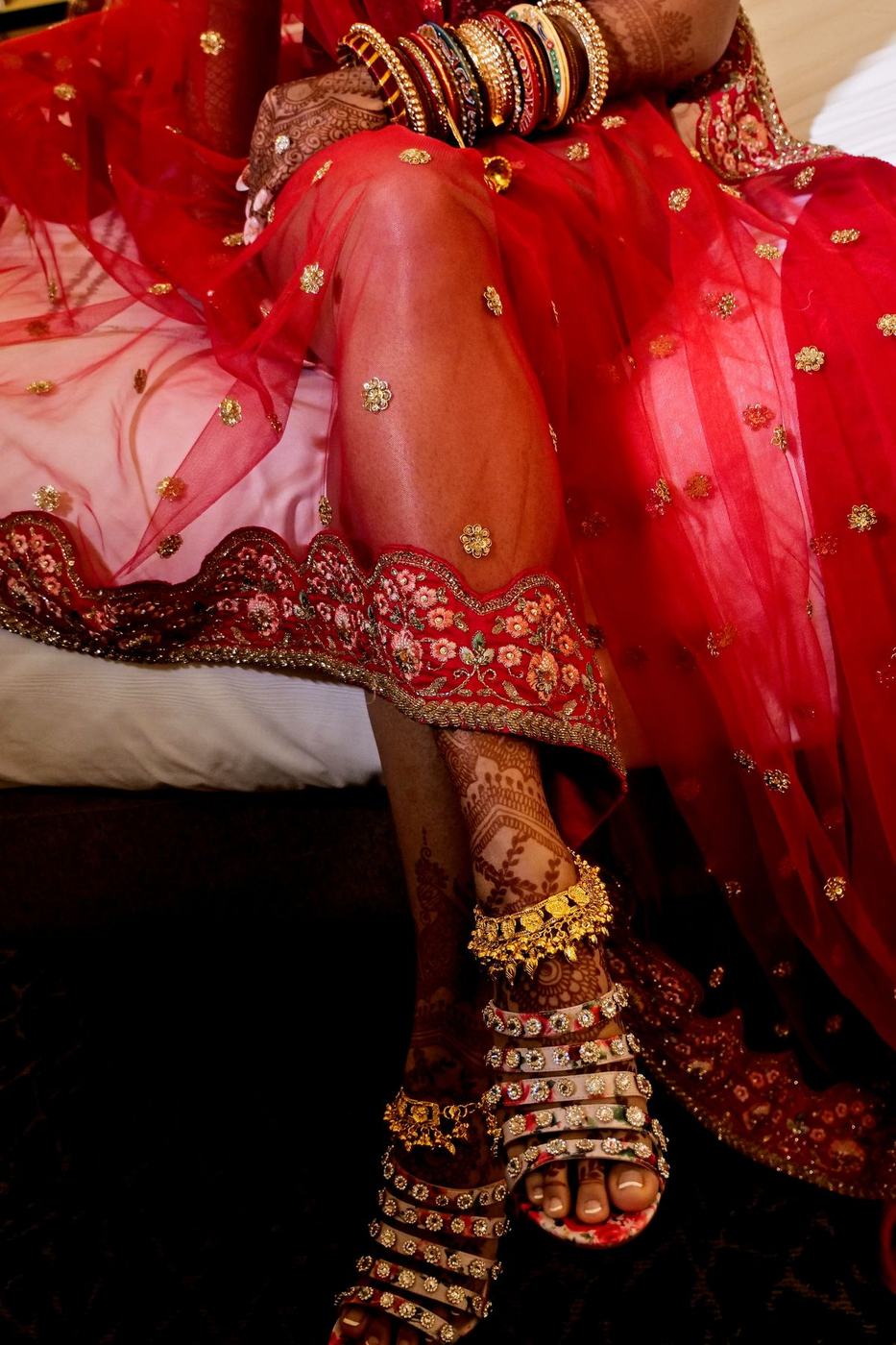 Jewelled bridal shoes beneath the red lehenga