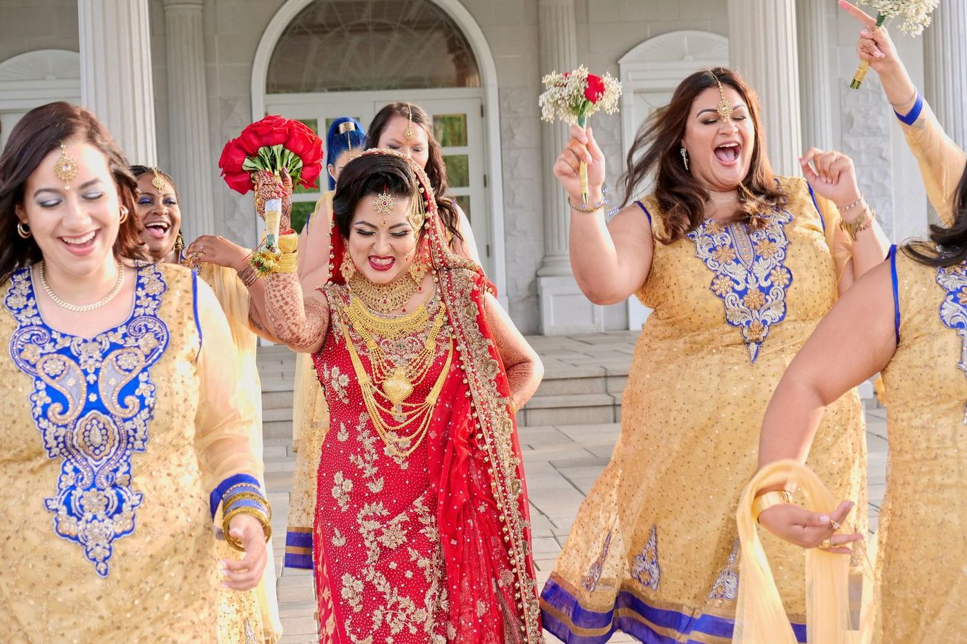 Bride and her friends cheering in red and gold