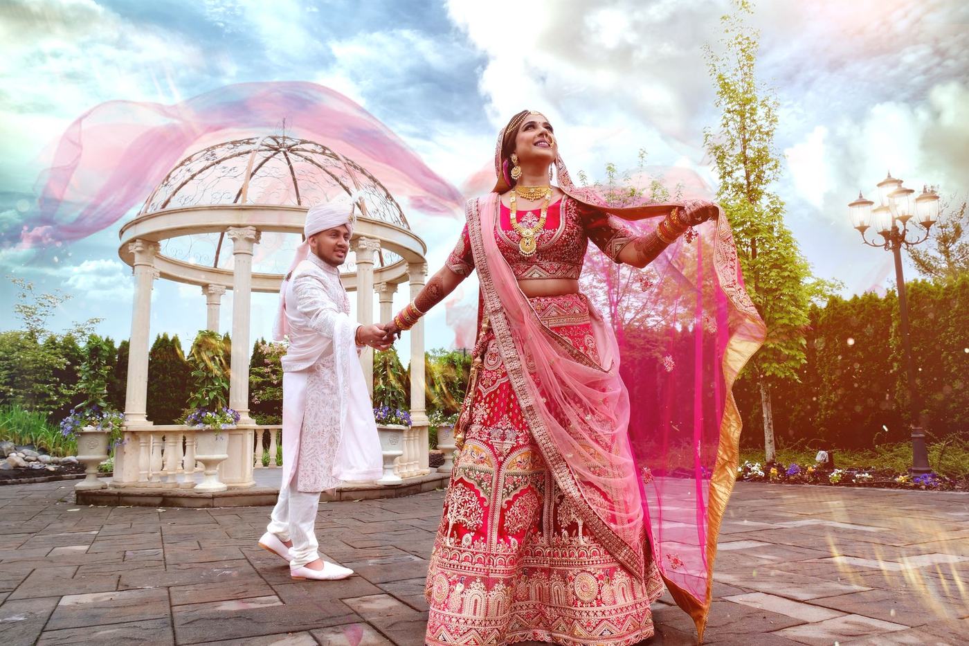 Bride in pink flinging her dupatta into the air at the gazebo
