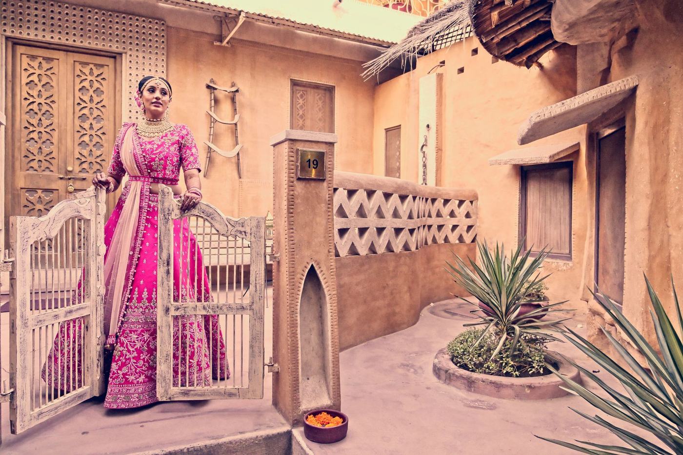 Bride in a pink lehenga in the courtyard of a heritage haveli