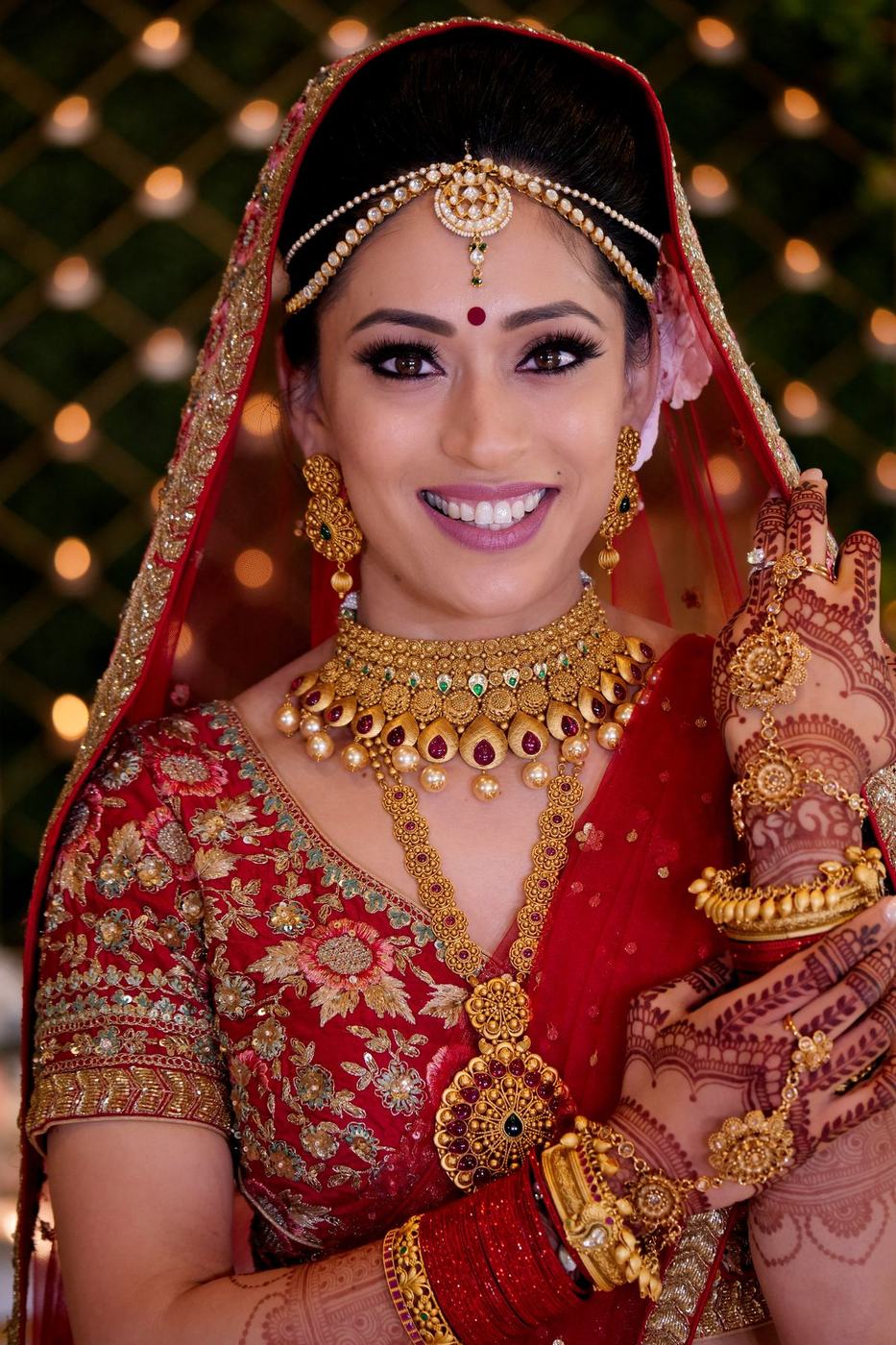 Bride in red and gold smiling straight at the camera