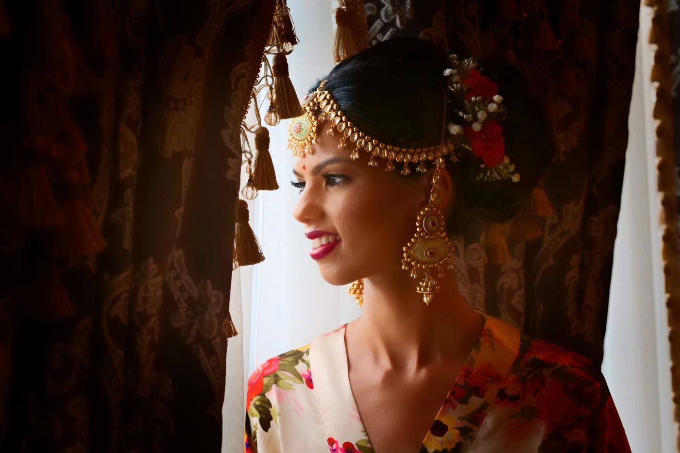 Bride at the window with jasmine in her hair, laughing