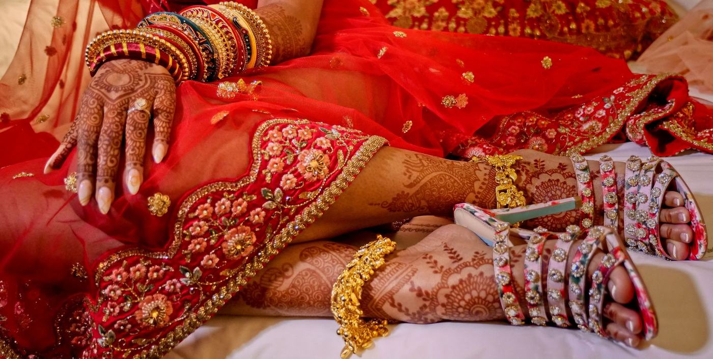 Bride's mehndi hands and anklets in red and gold