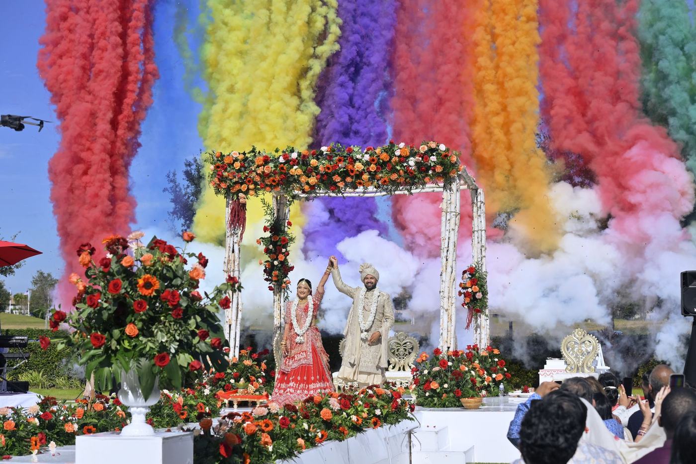 Coloured smoke rising over the outdoor mandap as the couple is married
