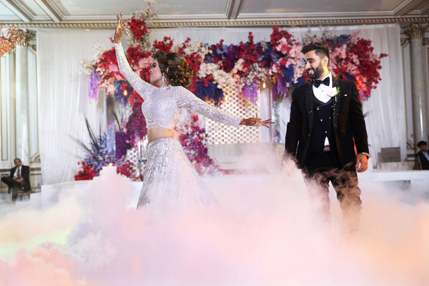 Couple before the floral arch in lilac smoke