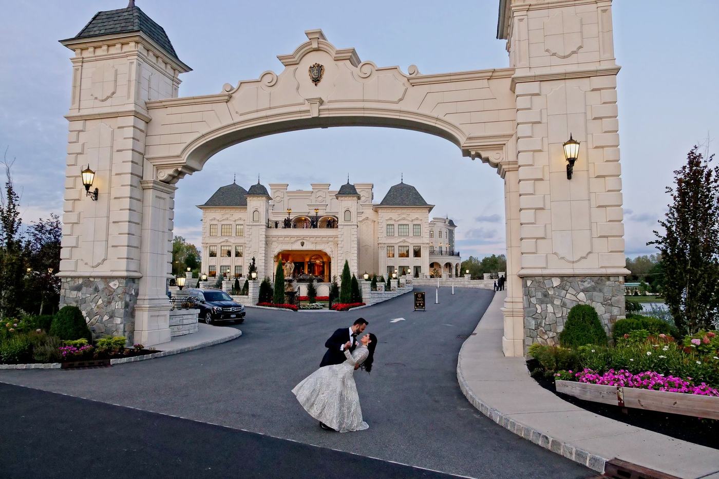 Couple beneath the stone archway of The Legacy Castle