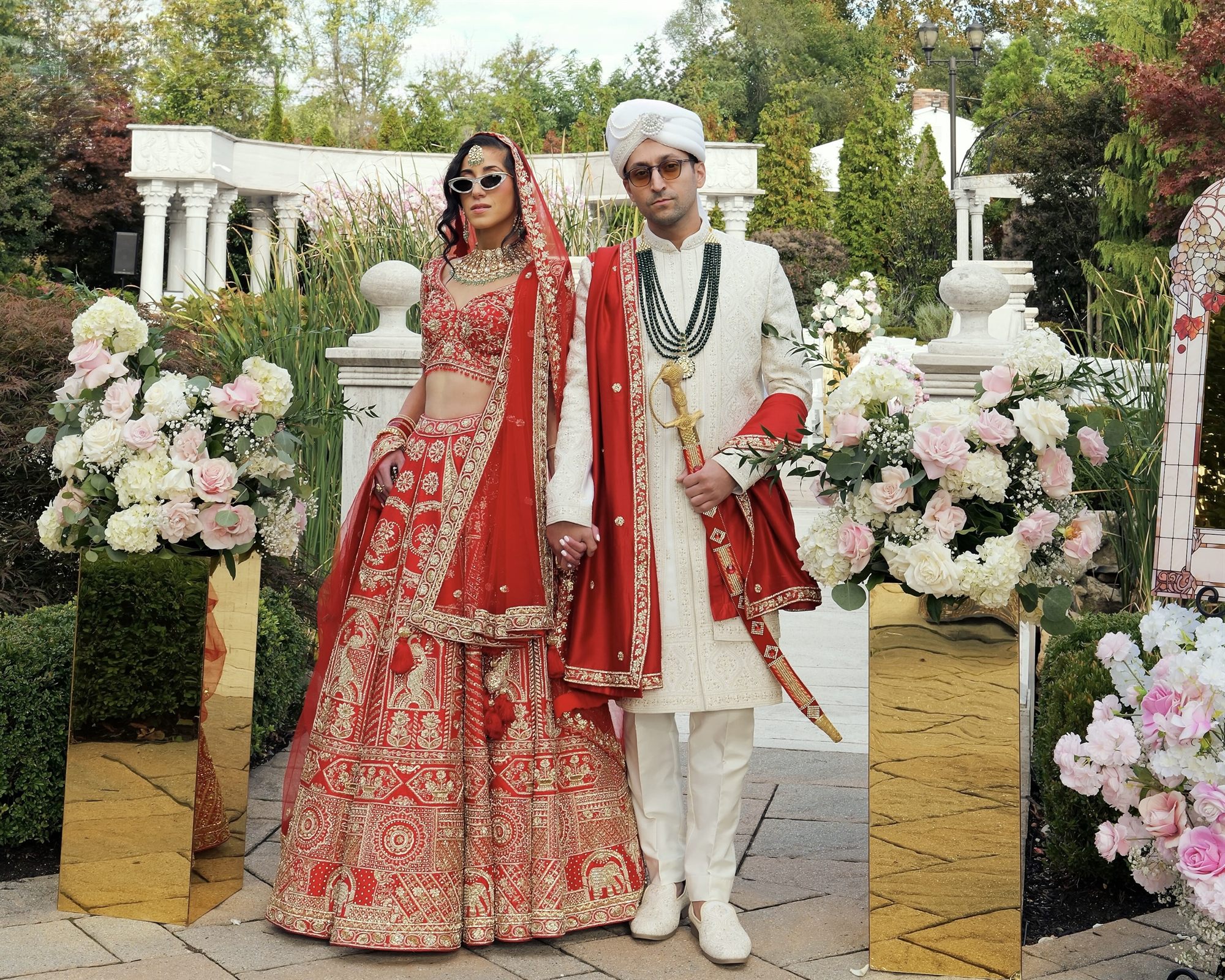 Couple with their families among white florals at a garden ceremony