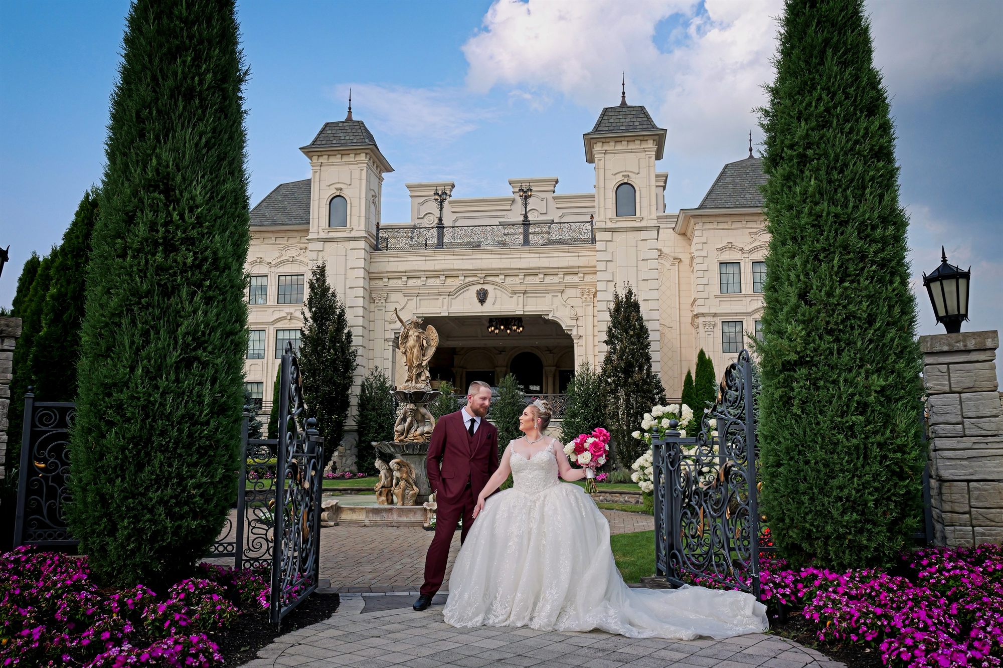 Couple standing at the gates of a historic estate