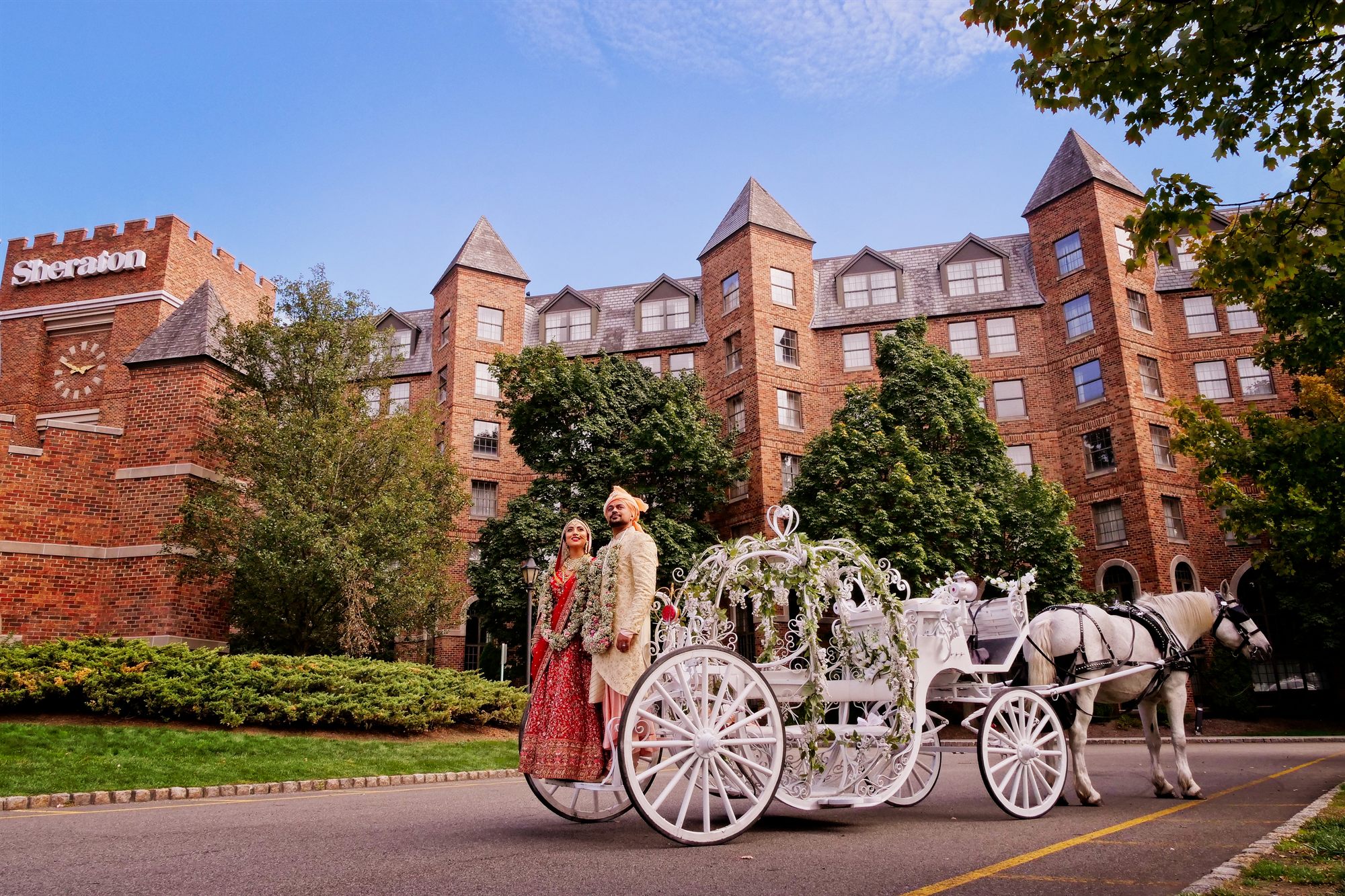 Couple arriving by horse-drawn carriage at a historic estate
