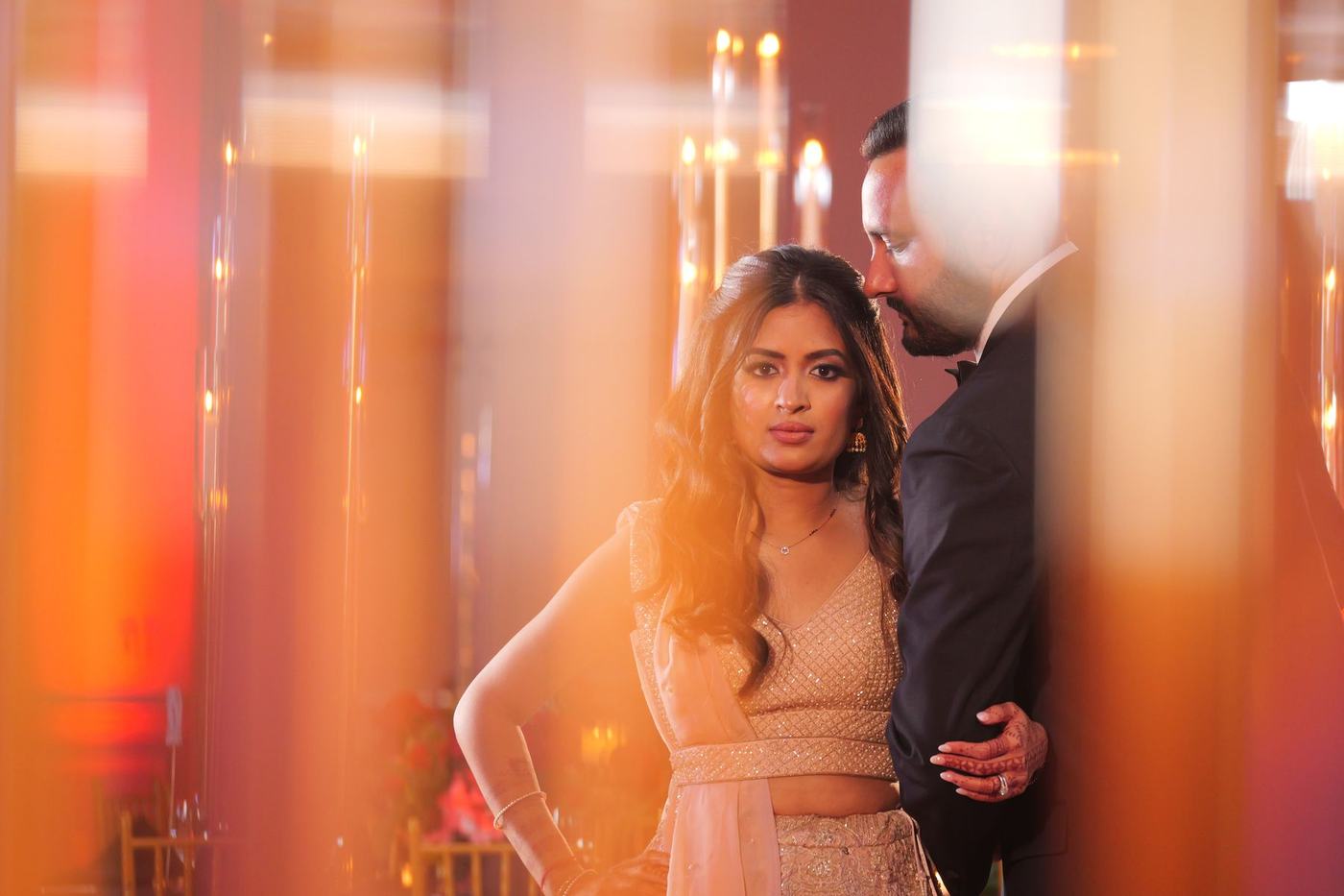 Couple close together in the candlelit reception hall