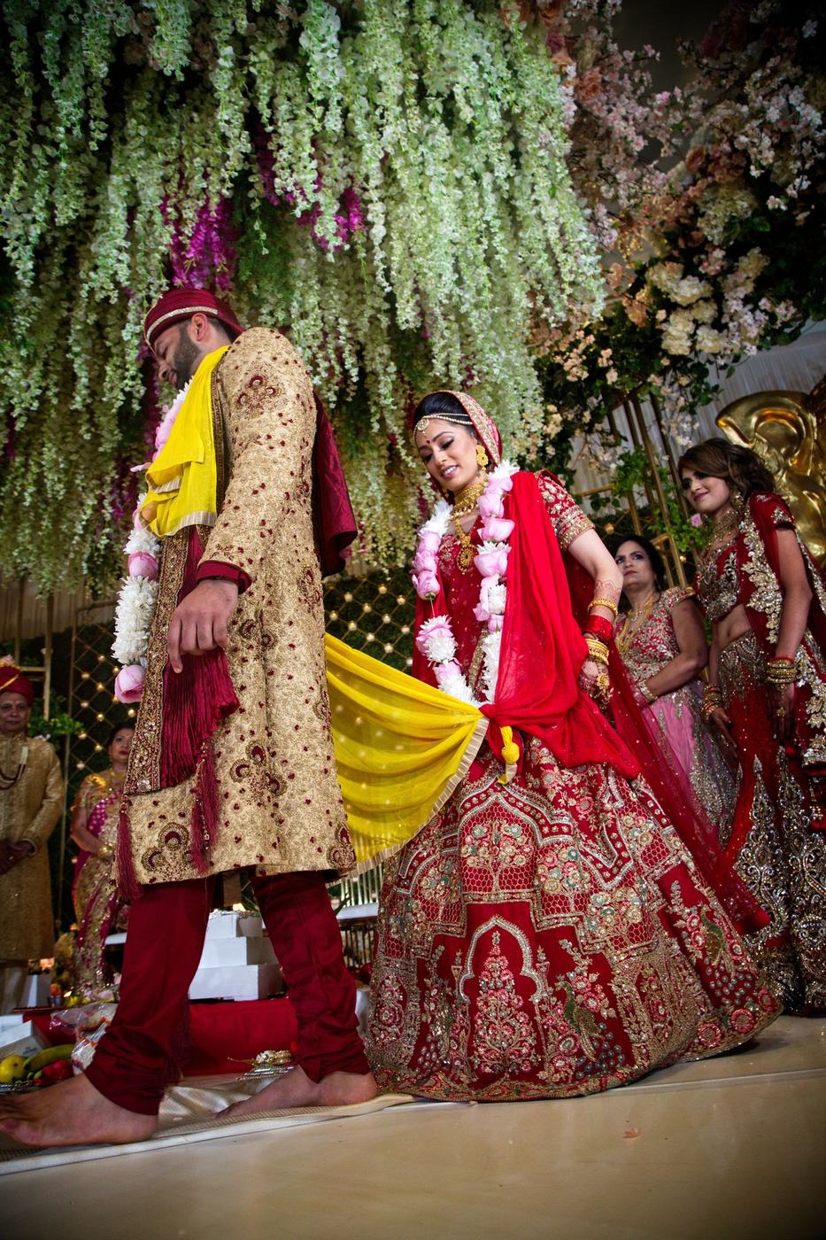 Couple in the mandap of hanging white blossoms