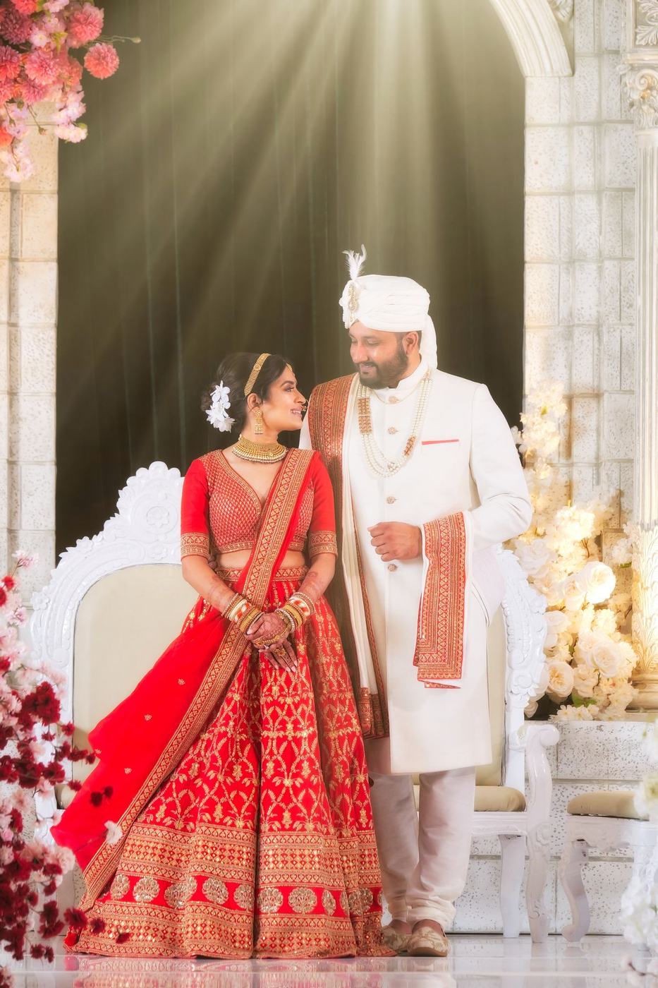 Couple stepping from the white floral mandap after the ceremony