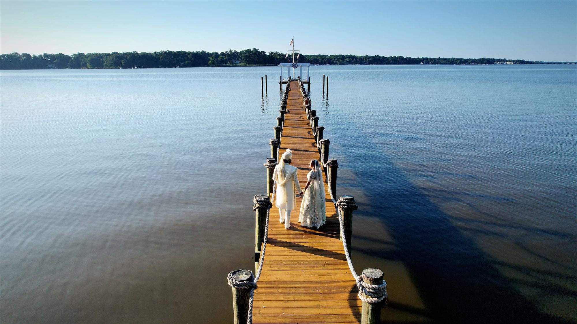 A long wooden pier reaching out across still water at the end of the day