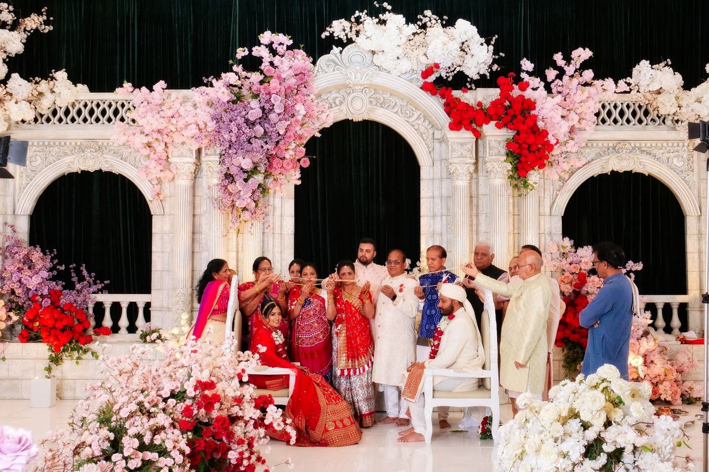 Both families gathered around a white mandap dressed in florals