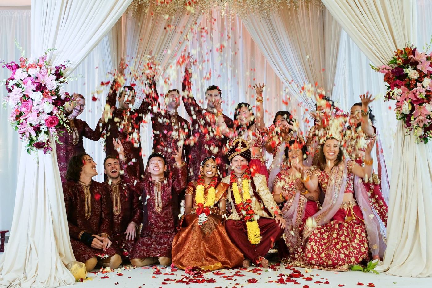 Both families cheering with the couple under the mandap drapes