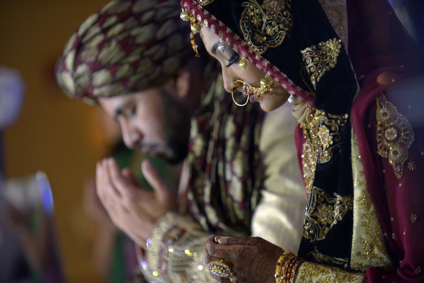 Groom in a green turban and gold sehra, close up