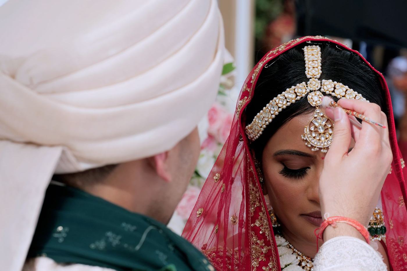 Groom placing sindoor in the bride's hair at the ceremony