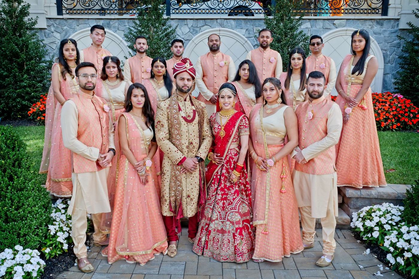 The whole wedding party in peach and ivory outside the estate