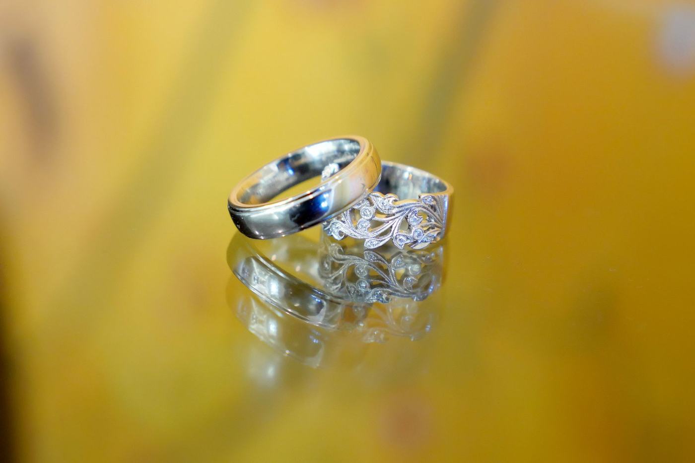 Two wedding rings resting on a yellow silk dupatta